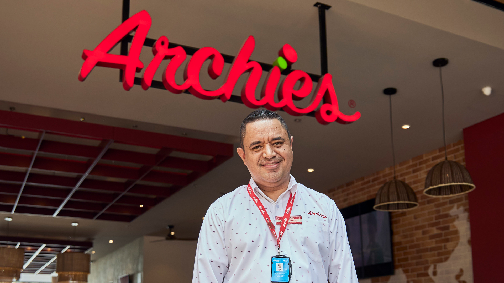 Archies restaurant interior with illuminated red logo and employee in uniform