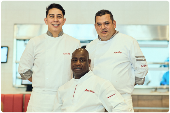 Three chefs in white uniforms