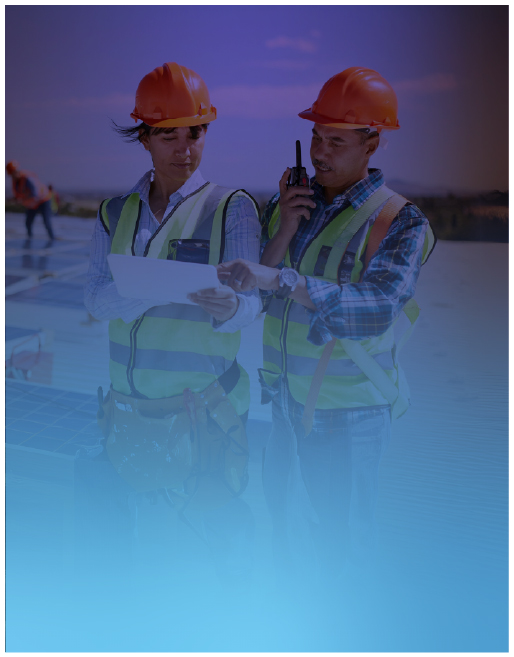 Two construction workers in safety vests and helmets reviewing plans