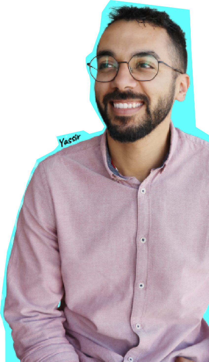Hombre sonriente con gafas y barba vistiendo una camisa rosa claro, mirando hacia un lado con una expresión amigable contra un fondo turquesa