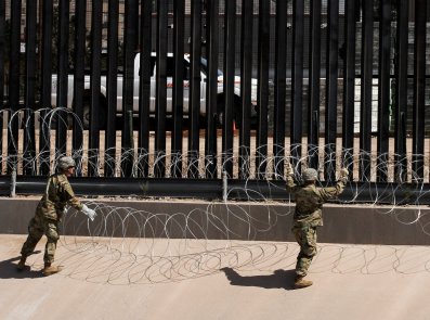 Soldiers wiring a fence